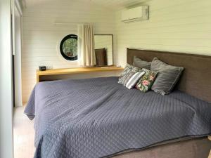 a bedroom with a bed with pillows and a mirror at Stylish House Between Beach And Forest In Tisvilde in Tisvilde +10 photos