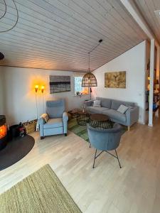 a living room with two chairs and a couch at Forest Cabin Overlooking Bryrup Langsø in Silkeborg