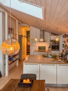 a kitchen with white cabinets and a ceiling with lights at Forest Cabin Overlooking Bryrup Langsø in Silkeborg