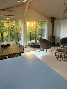 a living room with a table and chairs and a fireplace at Forest Cabin Overlooking Bryrup Langsø in Silkeborg +24 photos