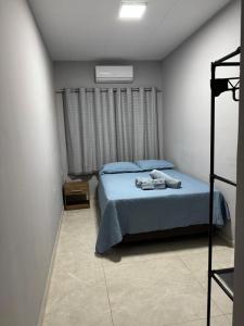 a bedroom with a bed with blue sheets and a ladder at Aconchego em Piranhas in Piranhas