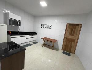 a small kitchen with a table and a wooden door at Aconchego em Piranhas in Piranhas
