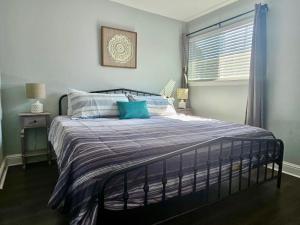 a bed with blue and white pillows in a bedroom at Seaside Gem in Biloxi +34 photos