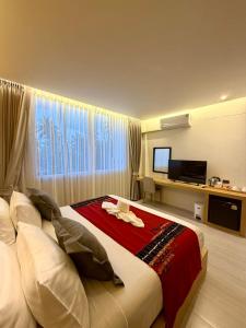 a bedroom with a large bed and a television at MM Hill Koh Samui Hotel - SHA Certified in Chaweng