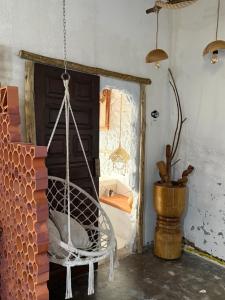a swinging chair in a room with a window at Desapegue & Viva Bed and Bikes in Ilhéus