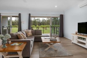 a living room with a couch and a table at 27 Rows on Hermitage in Pokolbin