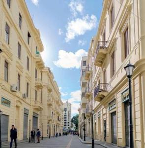 a street with buildings and people walking down the street at Nabi Daniel Residence بيت البنات in Alexandria