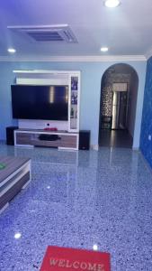 a living room with a flat screen tv and a large entertainment center at SriStar in Kluang