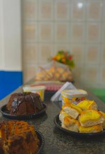 a table with three different types of pastries and cakes at Hotel Costa Rio in Rio das Ostras
