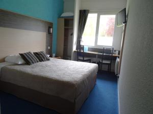 a hotel room with a bed and a desk and a window at Hotel Du Golf in Cabourg