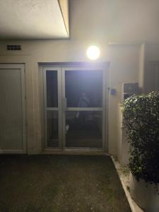 a man is standing in front of a sliding glass door at Apparte 104 avec Jacuzzi in Cap d'Agde +3 photos