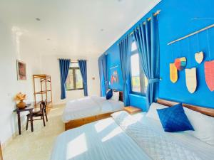 a bedroom with two beds and a blue wall at Peace Homestay Hoa Lư in Xuân Sơn +86 photos