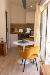 a table and chairs in a room with a kitchen at Studio le nid avec piscine partagée in Flayosc