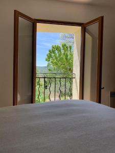 a room with a bed and a window with a view at Mas de la clue - 2 personnes in Figanières