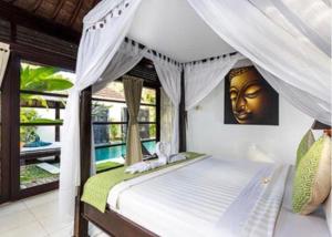 a bedroom with a bed with a gold face on the wall at Villa Kubu Pratiwi - Villa 2 in Canggu