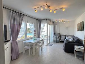 a living room with a table and a couch at BEACH FRONT APARTMENT in CALA MARSAL with the SEA VIEW ! in Portocolom