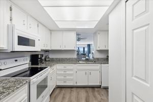 a white kitchen with white cabinets and appliances at Boardwalk 401 in Cocoa Beach
