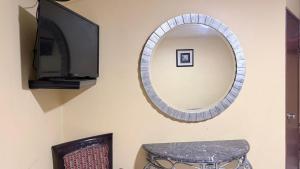 a mirror on a wall with a stool and a tv at Hotel Segovia in Tijuana