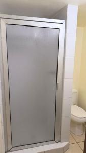 a glass shower door in a bathroom with a toilet at Hotel Segovia in Tijuana