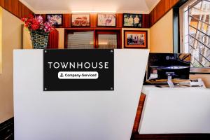 a sign for a townhouse and a computer on a counter at Townhouse Amrapali Resort in Kolhapur