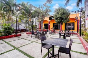 a patio with tables and chairs in front of a building at Townhouse Amrapali Resort in Kolhapur