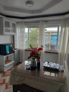 a living room with a table with flowers on it at Room Calapan in Camilmil