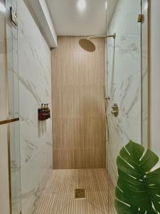 a shower with a glass door next to a plant at Spring Rooms by Yale & Downtown in New Haven