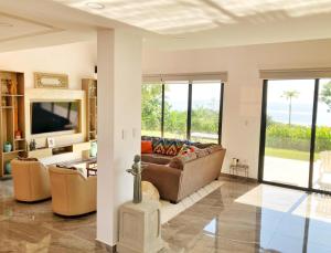 a living room with a couch and a tv at Samai Lodge Holistic Living in Olón