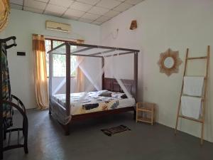 a bedroom with a canopy bed in a room at Sansayin Homestay in Hambantota +17 photos