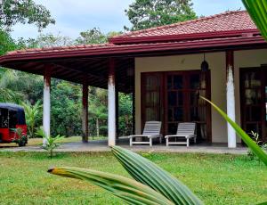 a house with two chairs and a porch at Sansayin Homestay in Hambantota
