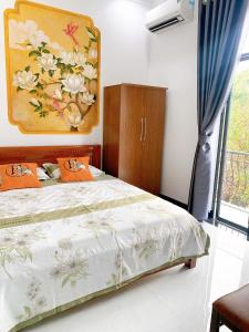 a bedroom with a bed and a painting on the wall at Hue Lotus Homestay in Hue