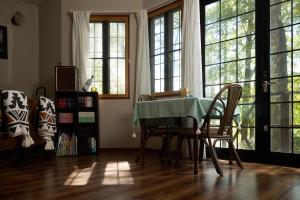 a dining room with a table and chairs and windows at カナリアンホテル in Tateshina +59 photos