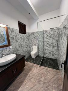 a bathroom with a shower and a toilet and a sink at Belgi Guest House in Balapitiya +28 photos