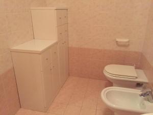 a bathroom with a toilet and a sink at Appartamento Piazza dei Monari in Cogolo