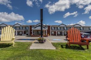 two chairs sitting in the grass in front of a building at Comfort Inn - Gander in Gander