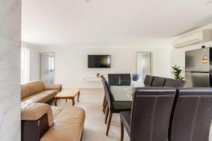 a living room with a couch and a table at Brand new fully accessible 5 bedroom house in Fairfield