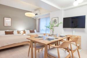 a room with a table and a bed and a couch at Feel Stay NAGOYA in Nagoya