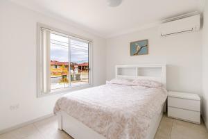 a white bedroom with a bed and a window at Brand new fully accessible 5 bedroom house in Fairfield