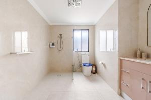 a white bathroom with a shower and a toilet at Brand new fully accessible 5 bedroom house in Fairfield +35 photos