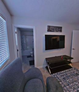 a living room with a couch and a flat screen tv at Atare Suite in Saskatoon