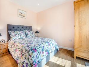 a bedroom with a bed with a floral bedspread at Jemmett Lodge in Kent