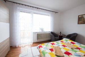 a bedroom with a bed and a large window at Domcek na orave in Habovka