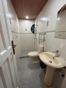 a white bathroom with a sink and a toilet at Talna in Baguio +13 photos