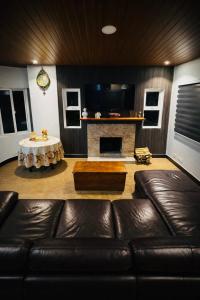 a living room with a leather couch and a fireplace at Talna in Baguio