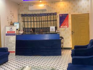 a waiting room with blue chairs and a counter at Glorious Guest House & Hotel in Multan