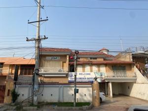 a building with a street sign in front of it at Glorious Guest House & Hotel in Multan