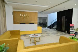 a lobby with couches and a table and stairs at Lumis Hotel Whitefield in Bangalore