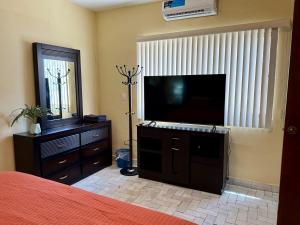a bedroom with a bed and a flat screen tv at Casa completa, Excelente ubicación, Cerca IMSS in Torreón