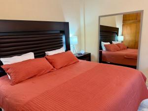 a bedroom with a large orange bed and a mirror at Casa completa, Excelente ubicación, Cerca IMSS in Torreón