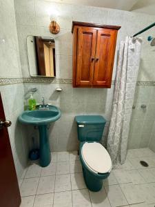 a bathroom with a blue toilet and a sink at Casa completa, Excelente ubicación, Cerca IMSS in Torreón
